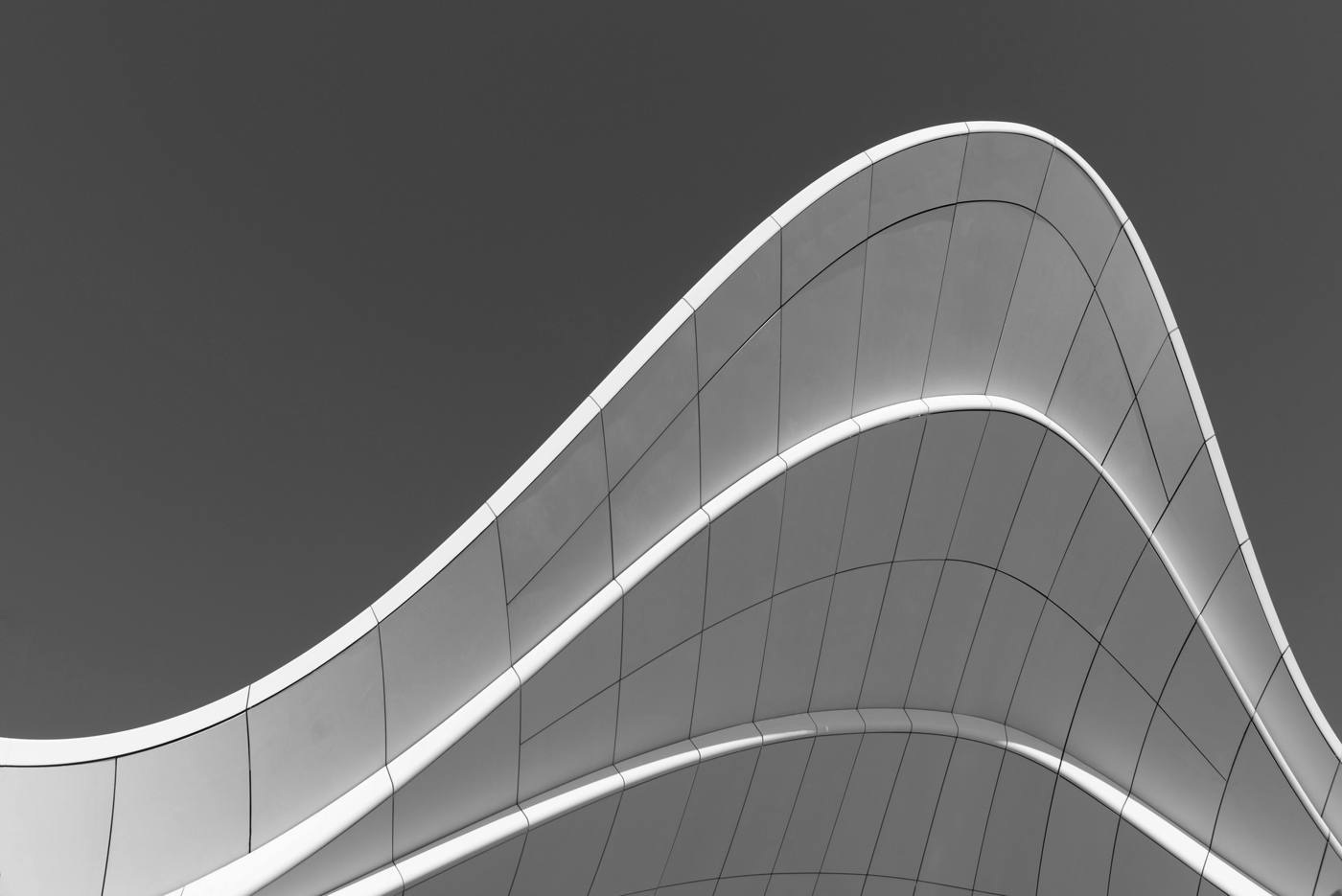 Curved modern facade against a dark sky